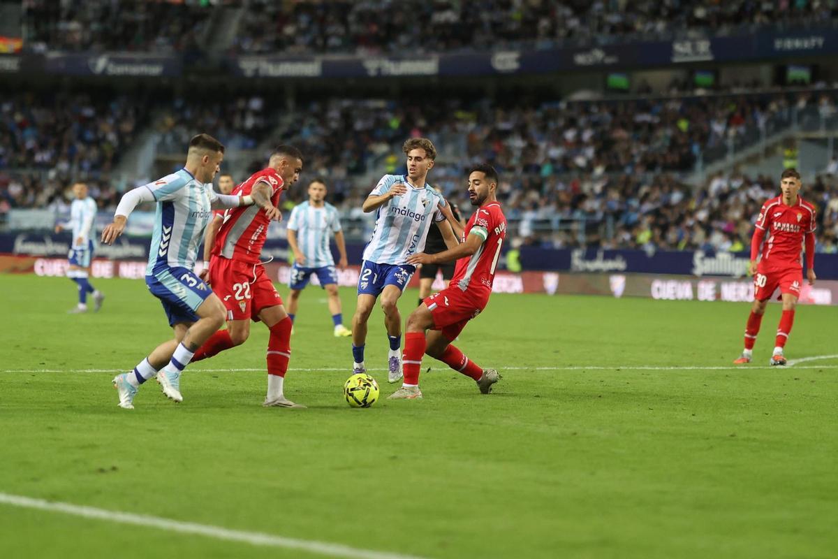 Carlos Isaac y Rubén Alves protegen el esférico durante un lance del Málaga-Córdoba CF.