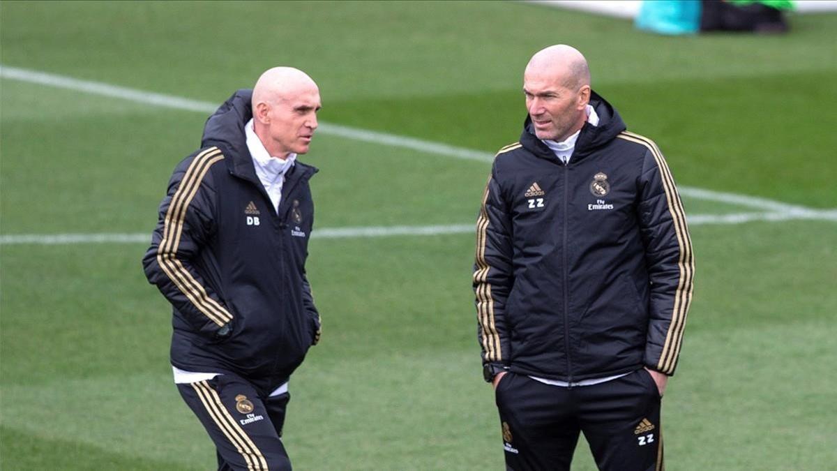 Zinedine Zidane (derecha) charla con su asistente, David Bettoni, en el último entrenamiento del Madrid antes de viajar a Vitoria.