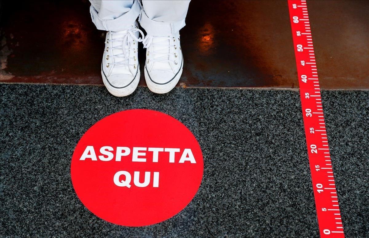 Marcadores de distanciamiento social en la entrada de un café cerca del Coliseo.