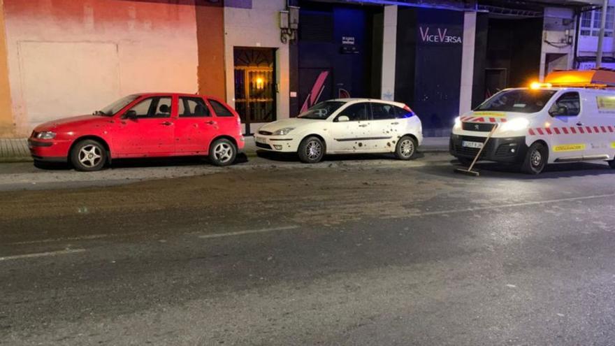 Purín sobre el asfalto de la N-640 a su paso por el casco urbano de A Estrada y algunos de los vehículos que resultaron salpicados. En la imagen, comenzaban las labores de limpieza de la avenida Benito Vigo.  | // L.D.