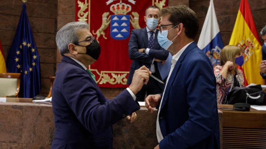 Román Rodríguez, bolígrafo en mano, charla, ayer, con el diputado socialista Iñaki Lavandera momentos antes de la comisión parlamentaria.