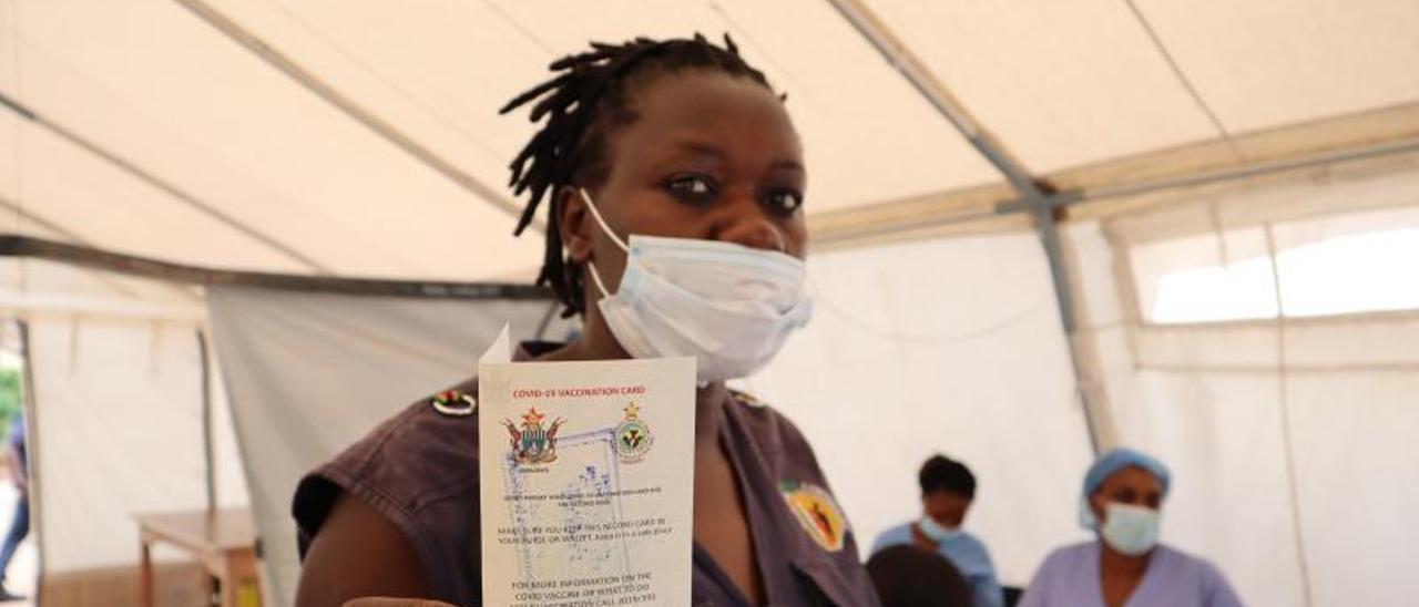 Una sudafricana muestra su cartilla de vacunación.