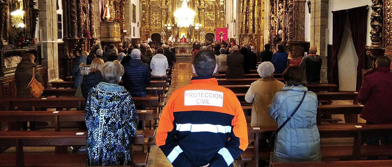 Un voluntario de Protección Civil, en el centro de la imagen, durante la misa del Socorro celebrada ayer con el aforo restringido.