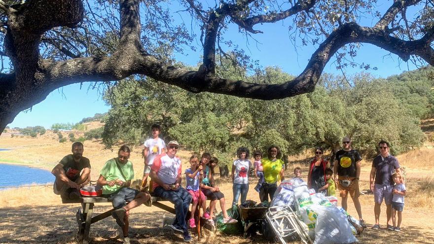 Voluntarios participan en una jornada de limpieza de las márgenes del pantano de Tentudía