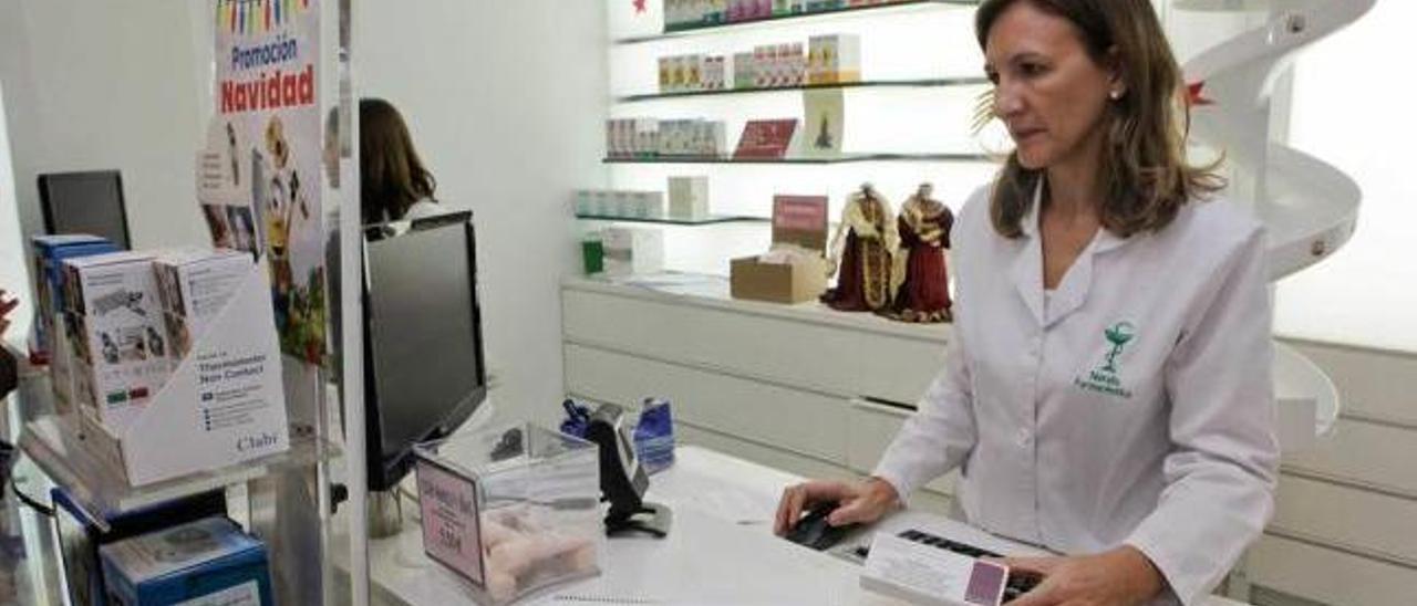 Una farmacéutica, con el registro de familias que han hecho reserva para disponer de la vacuna.