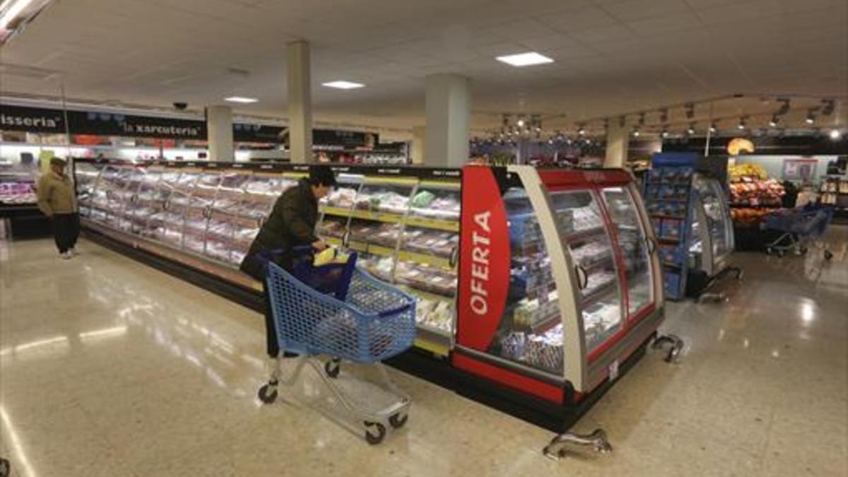 Una mujer mira la oferta en un supermercado del barrio de Gràcia.