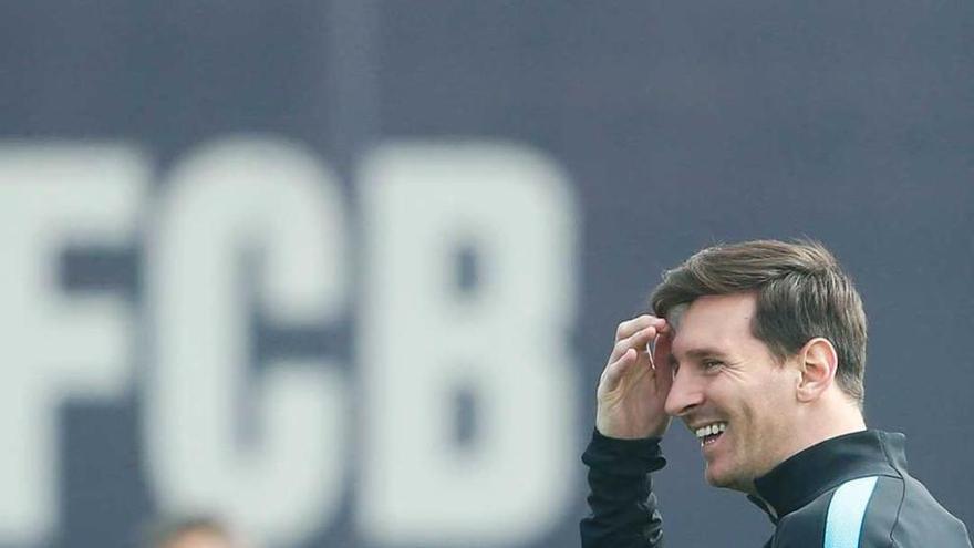 Messi, sonriente en el entrenamiento de ayer, con Luis Enrique al fondo.