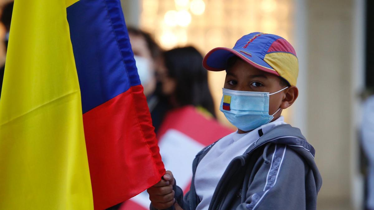 Un niño porta una bandera de Colombia en la concentración de apoyo al país en el Bulevar del Gran Capitán.