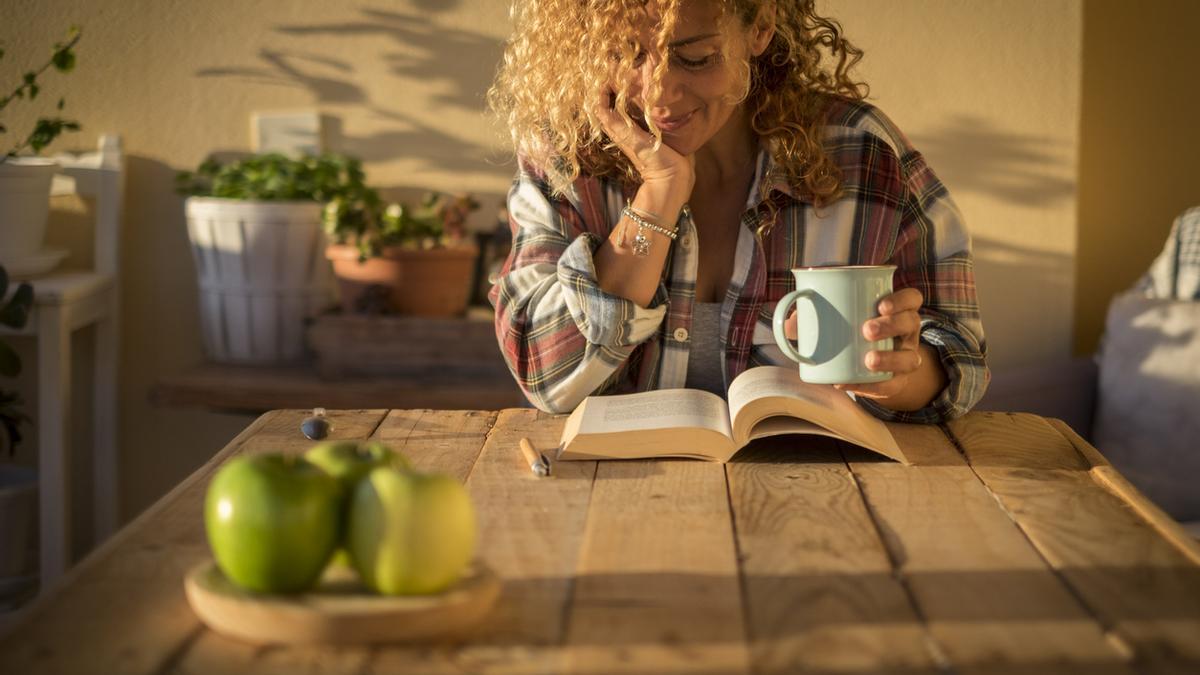 Mujer leyendo con una taza de café