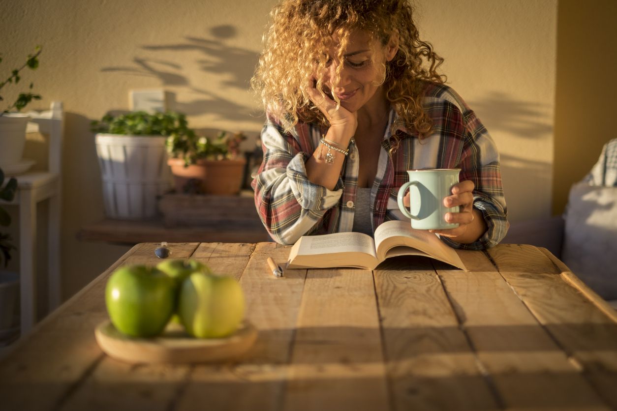 Mujer leyendo con una taza de café