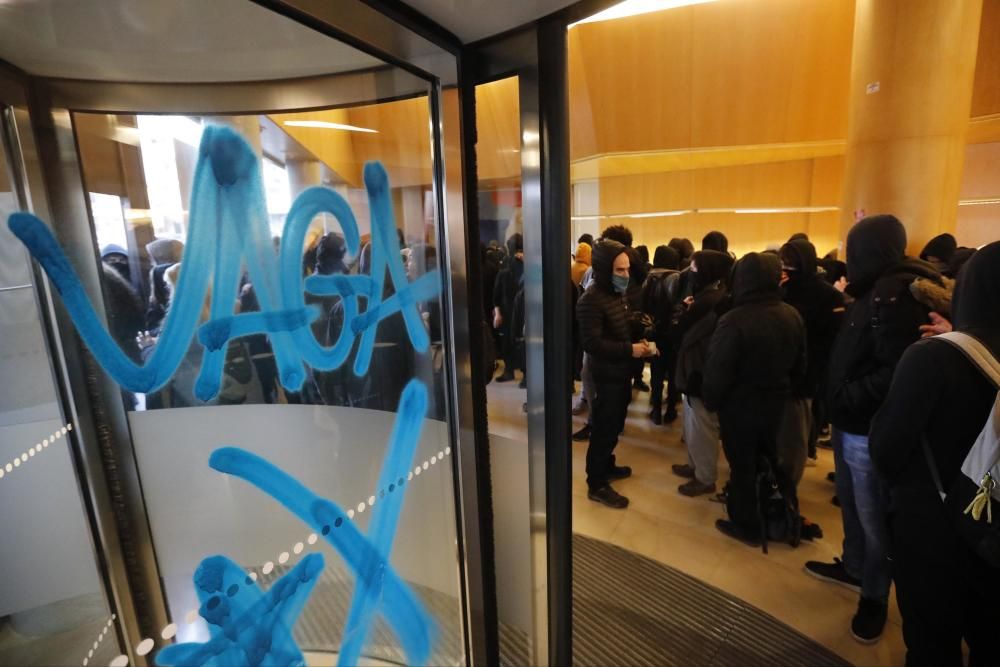 Els manifestant fan pintades i empaperen l'entrada de la seu de CaixaBank a Girona