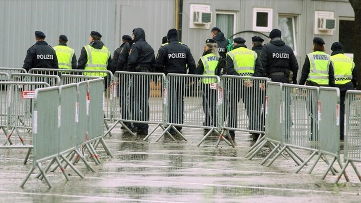 Agentes de policía caminan por detrás de una vallas en un centro de registro de migrantes en Spielfeld (Austria), en la frontera con Eslovenia.