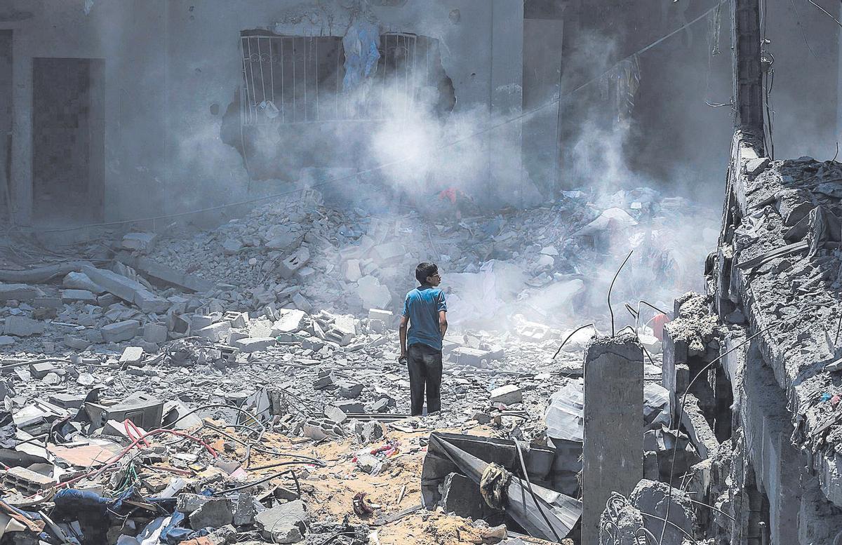 Un joven observa la destrucción de un edificio en Gaza, este martes, en un nuevo ataque israelí.