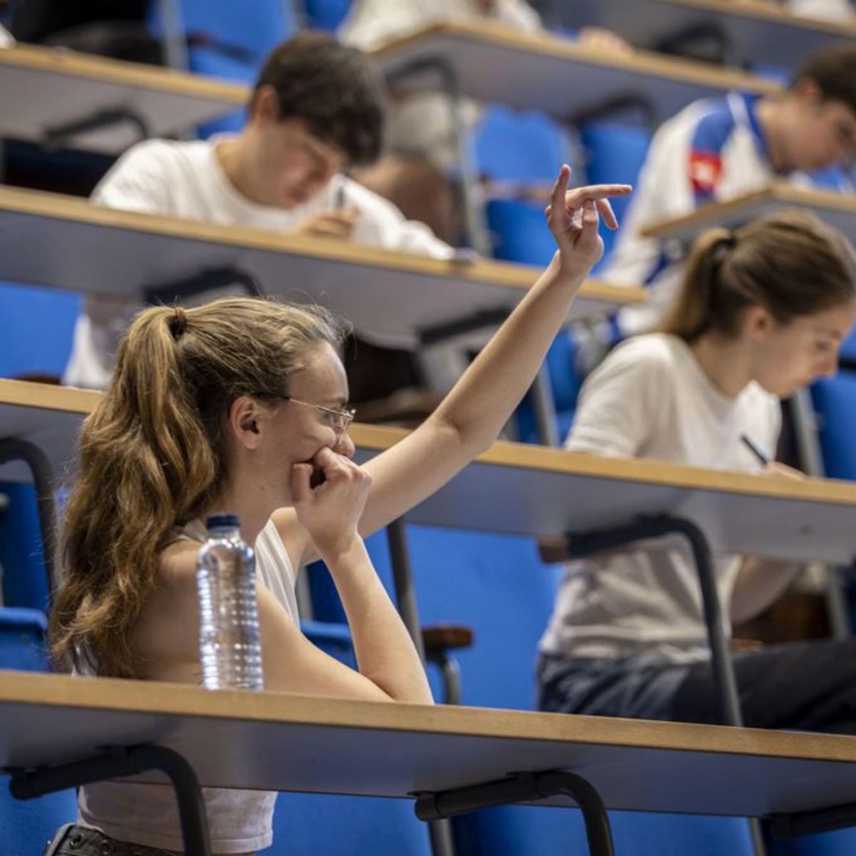 Una estudiant aixeca la mà per demanar un torn  de paraula durant una classe. | MIGUEL ÁNGEL GARCÍA