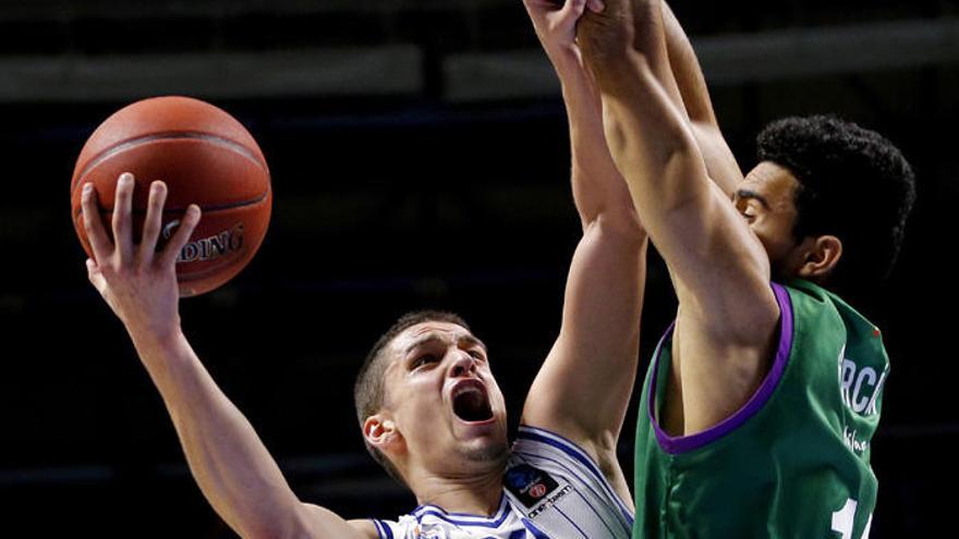 El base montenegrino del Buducnost Petar Popovic (i), entra a canasta ante el ala-pívot dominicano del Unicaja Juan José García, durante el partido de la séptima jornada de la Eurocopa en el Carpena.