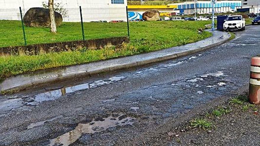 Baches, rocas de un desprendimiento y vista de noche del acceso al polígono, con luces solo al fondo en la gasolinera.