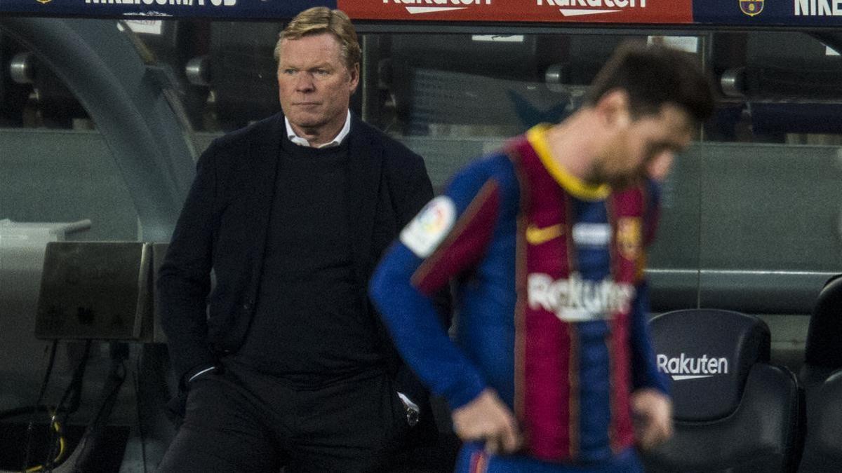 Koeman, con semblante serio, detrás de un decepcionado Messi.