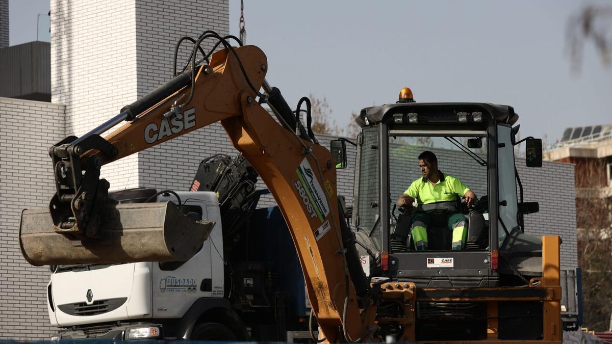 Un trabajador de la construcción, con una máquina excavadora