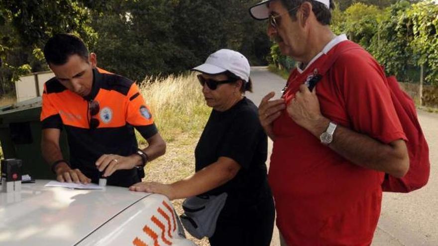 Miembros de Protección Civil de Valga atienden a un grupo de peregrinos.  // Noé Parga