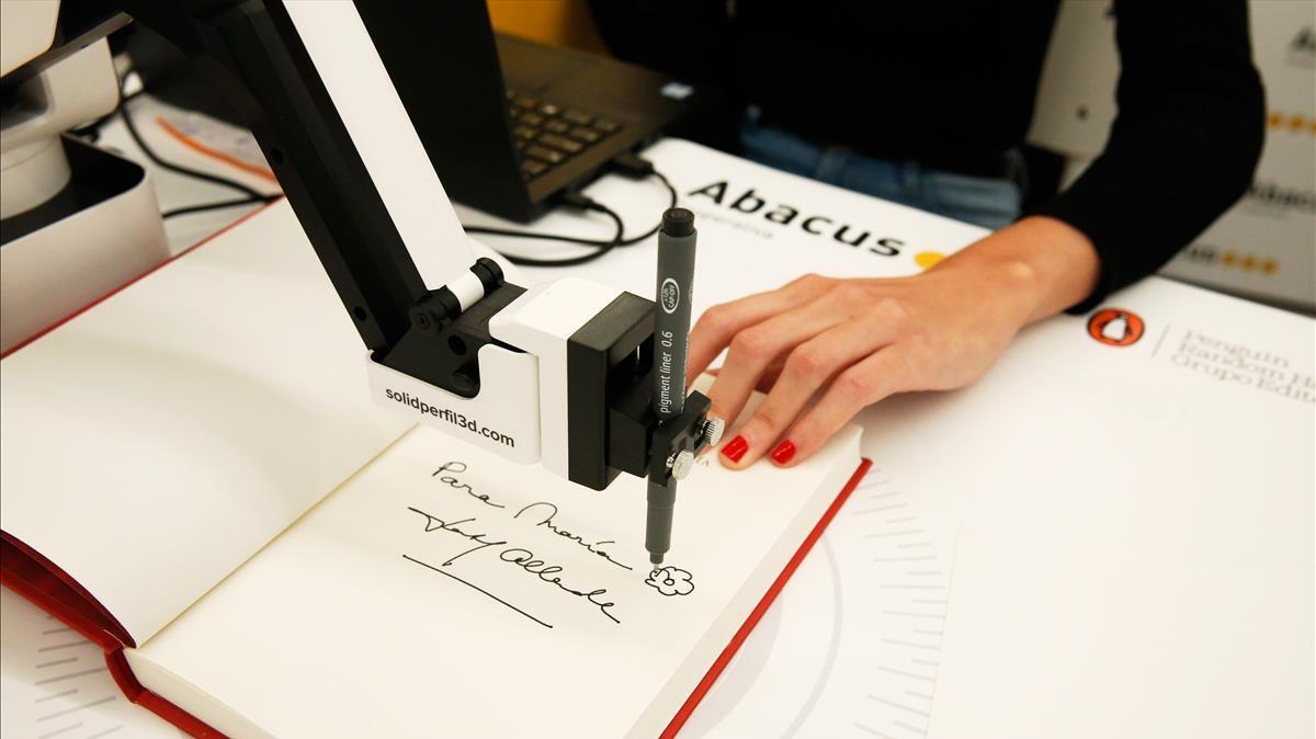 Isabel Allende firma libros en la librería Abacus de Enric Granados vía internet y brazo robotizado.