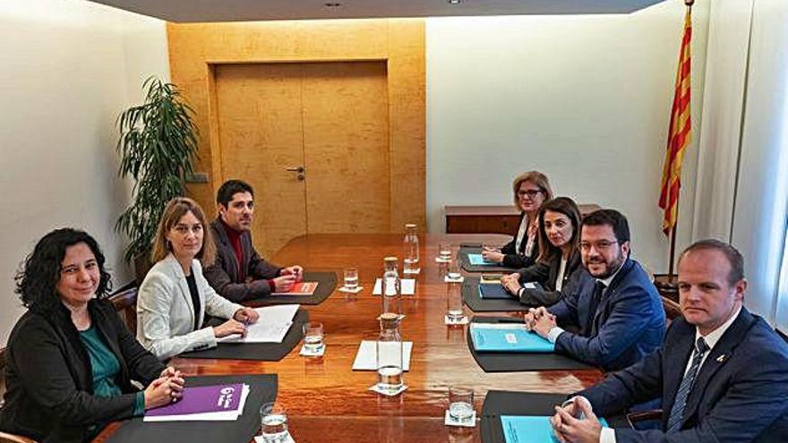 Els equips negociadors dels comuns (esquerra) i el Govern, ahir a Barcelona.