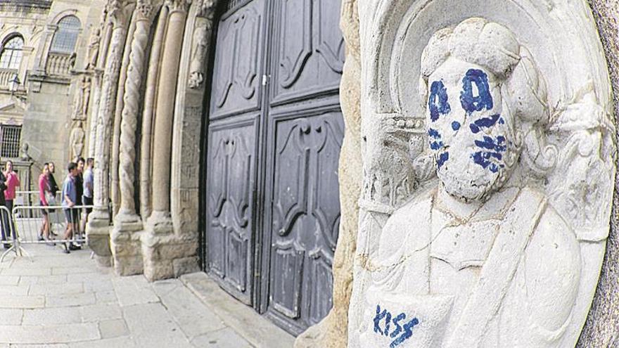 Un gamberro pinta un grafiti en la catedral de Santiago