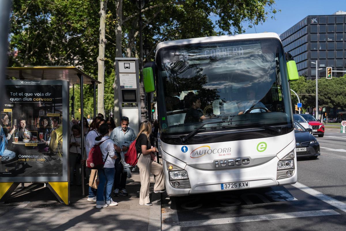 Usuarios, trabajadores y estudiantes hacen cola para subir a los autobuses Exprés.cat en las paradas de Diagonal con Maria Cristina