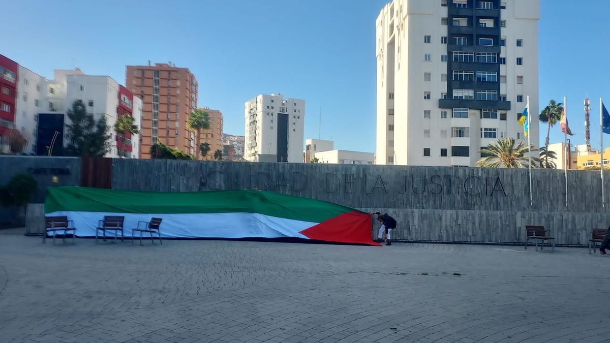 Profesionales de la justicia y activistas despliegan una gran bandera de Palestina en los juzgados de Las Palmas de Gran Canaria