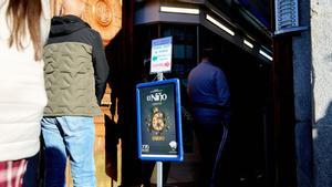 arias personas hacen cola en una administración de lotería para comprar décimos de cara al Sorteo de El Niño.