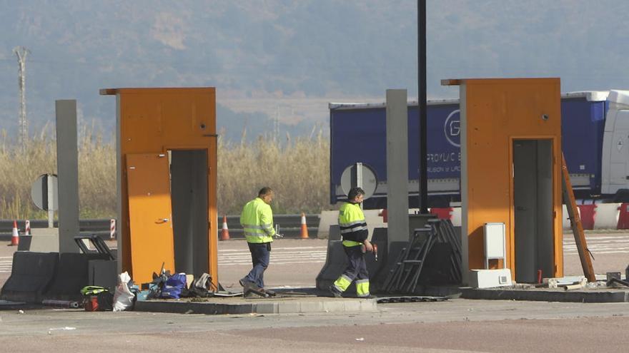 Operarios trabajan desmontando el peaje de la autopista a la altura de Faura..