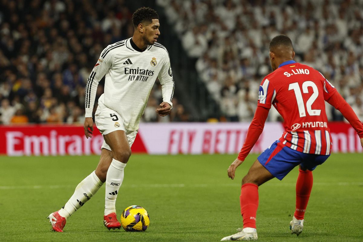 MADRID, 08/02/2025.- El centrocampista del Real Madrid Jude Bellingham (i) juega un balón ante Samuel Lino, del Atlético, durante el partido de LaLiga de fútbol que Real Madrid y Atlético de Madrid disputan este sábado en el estadio Santiago Bernabéu. EFE/Chema Moya