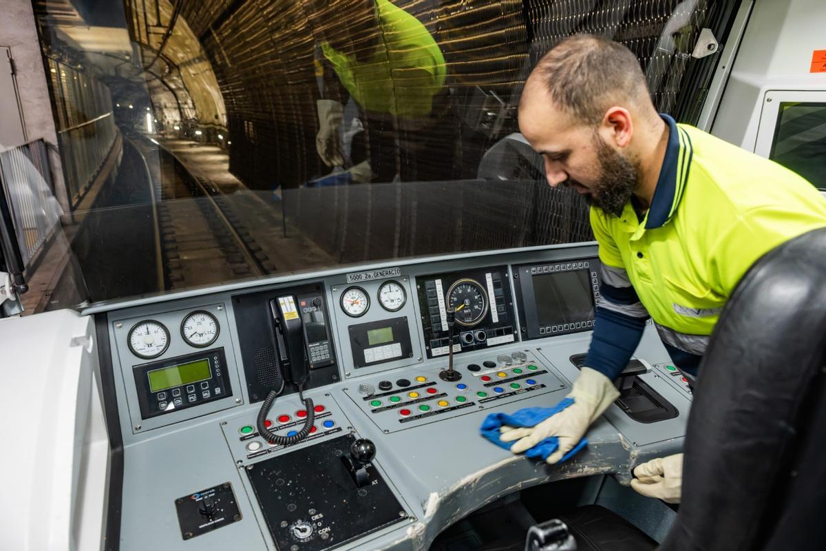 Un trabajador limpiando en la cabina de un tren del metro, en Barcelona.