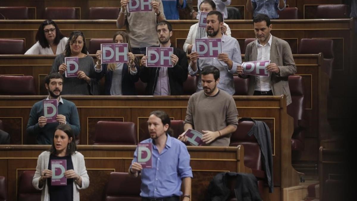 Diputados de Podemos muestran carteles a favor de los derechos humanos al inicio del pleno del Congreso.
