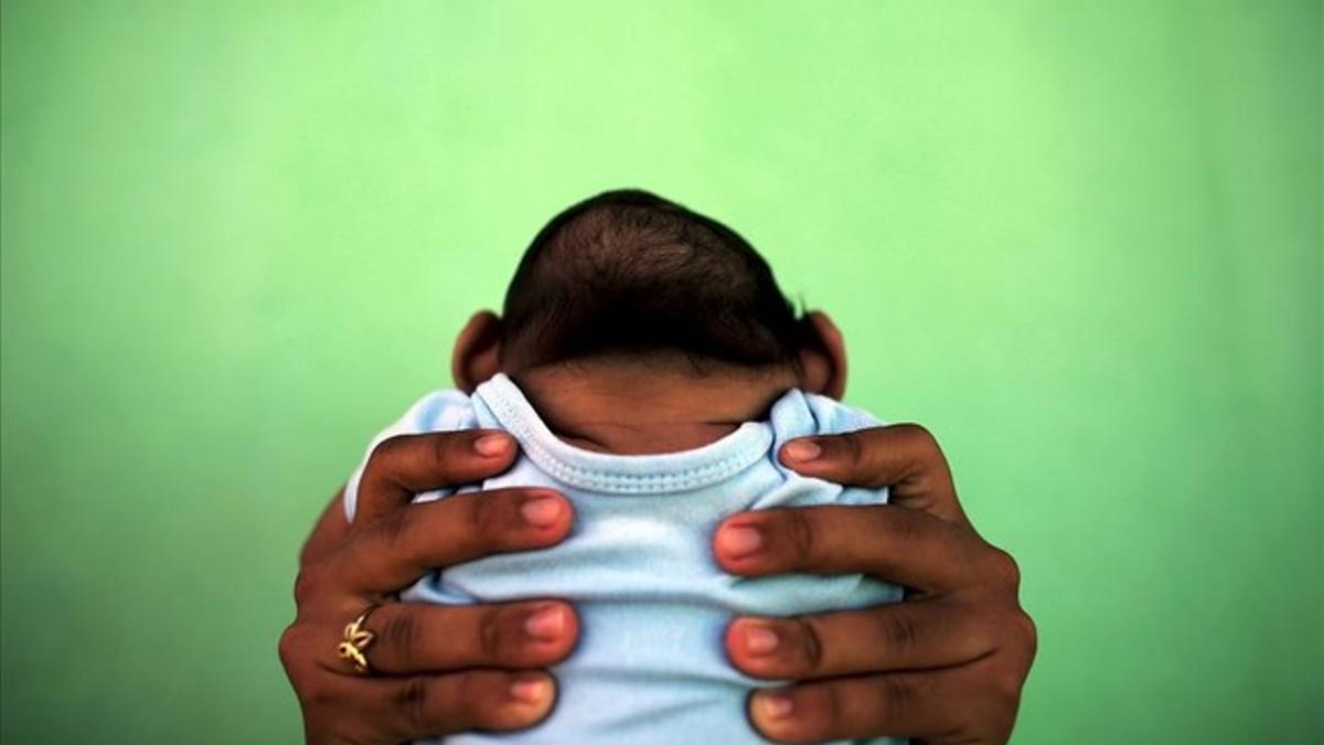 Jackeline sostiene a su hijo de 4 meses de edad y nacido con (Zika) microcefália frente a su casa en Olinda, cerca de Recife, Brasil.