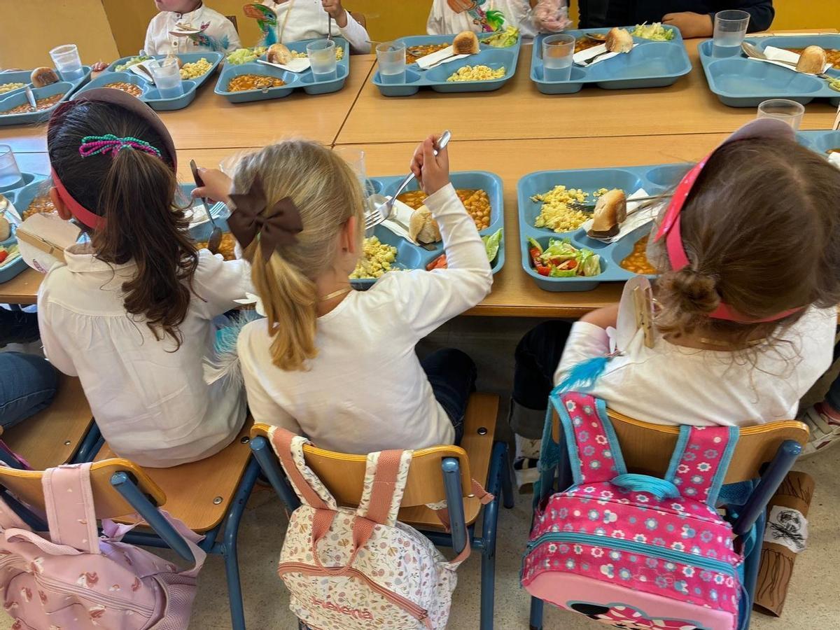 Un grupo de niños come en un centro escolar.