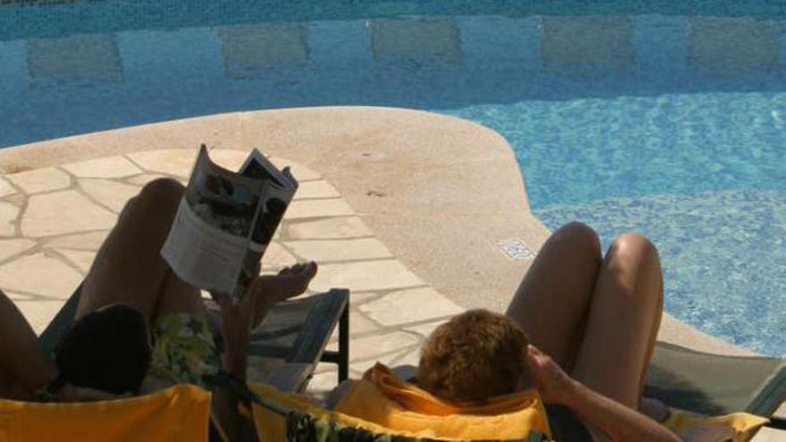 Una pareja se relaja frente a la piscina en el hotel Montíboli de Villajoyosa.