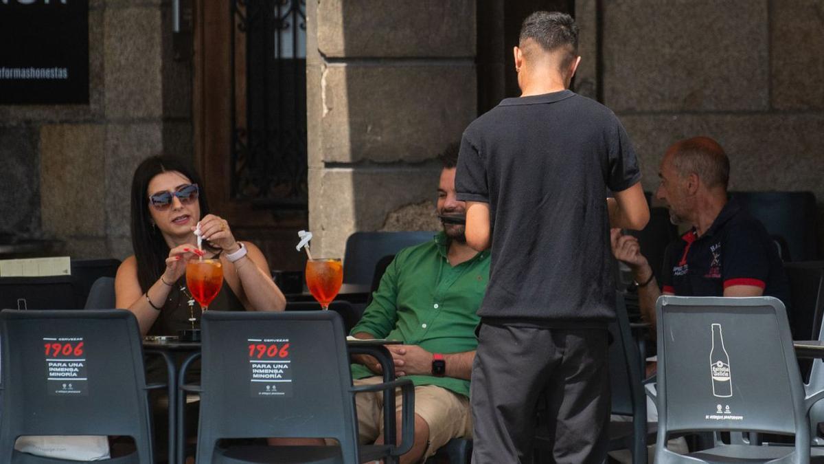 Un camarero atiende a los clientes de un bar en A Coruña.