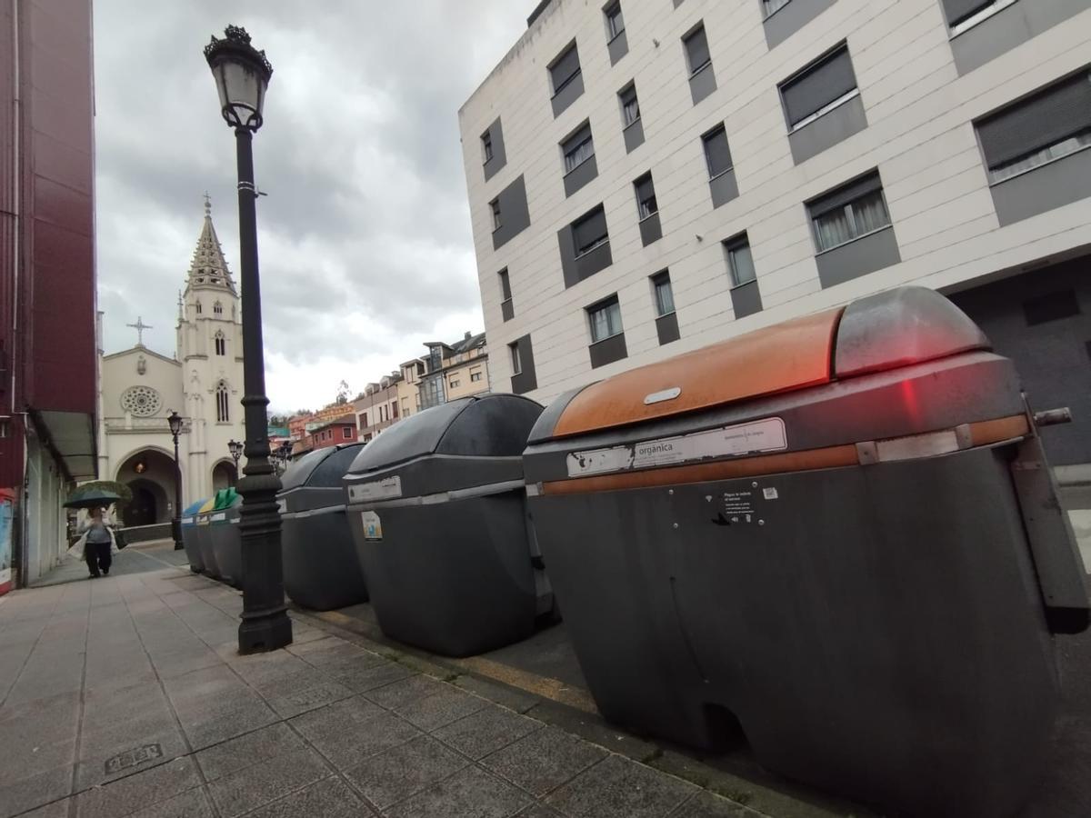 Un contenedor de basura orgánica, en primer término, en Sama.