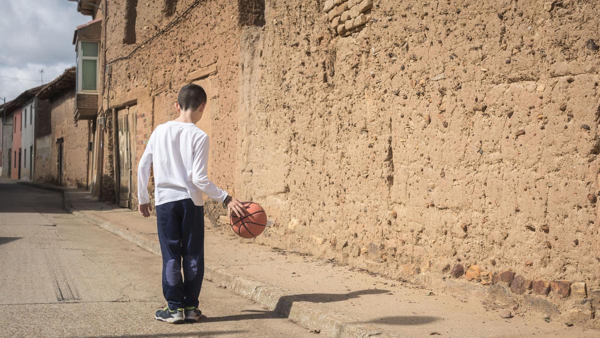 Un niño juega en las calles de un pueblo de la España vaciada.