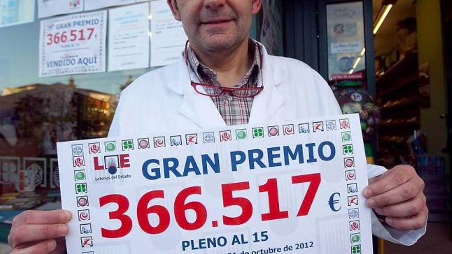 veinte agraciados y un librero feliz. Javier Blanco, en la foto, con un cartel que anuncia el premio, es el dueño de la librería donde fue sellado el boleto afortunado. Él mismo impulsó la peña quinielística de veinte miembros ahora ganadora, que todas las semanas juega 200 euros.