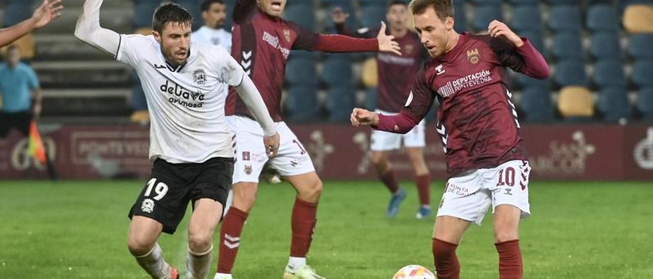 Yelko Pino (derecha) controla un balón ante la atenta mirada de Iribas (derecha) y Charles (centro).