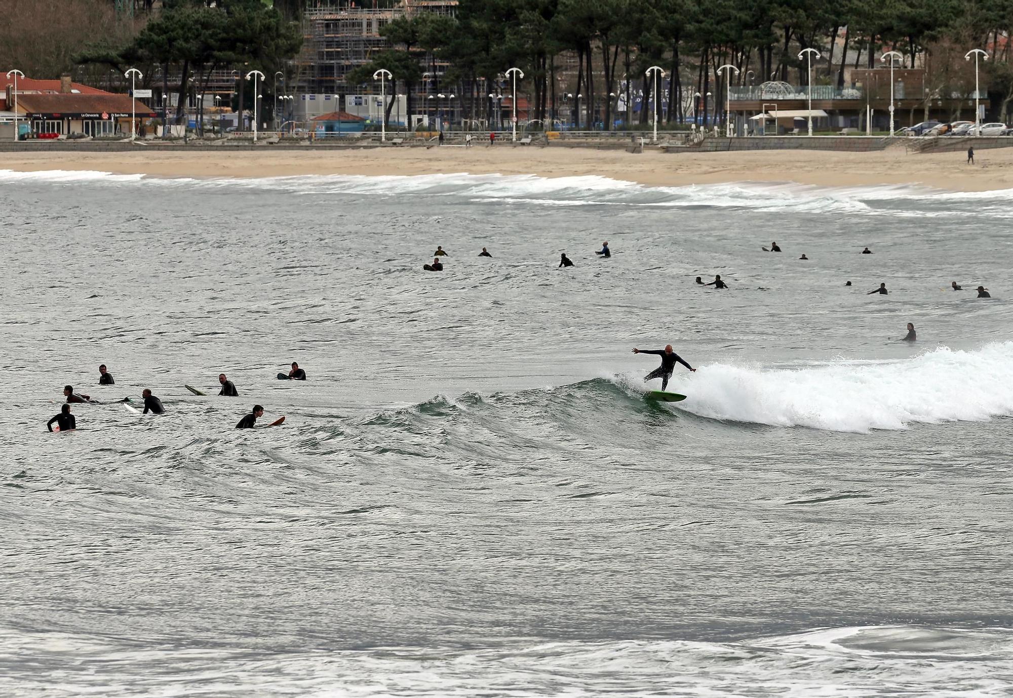 Surfistas practicando  junto a la desembocadura del río Lagares y la playa de Samil