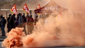 Trabajadores de TotalEnergies y Esso ExxonMobil lanzan una bomba de humo de colores durante una protesta convocada por el sindicato CGT en La Mede, Francia.