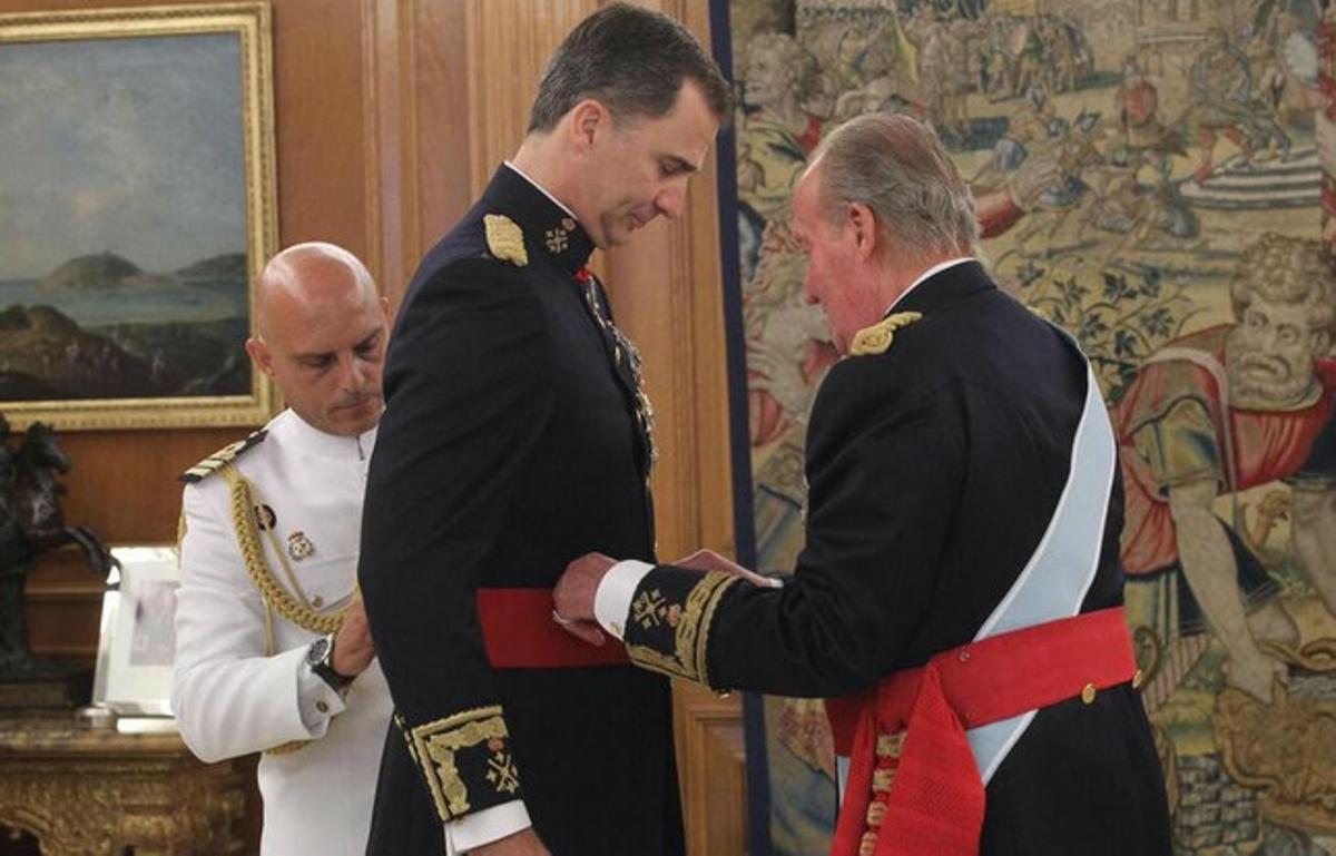 Juan Carlos le impone a Felipe VI el fajín de capitán general de las Fuerzas Armadas, en el palacio de la Zarzuela.