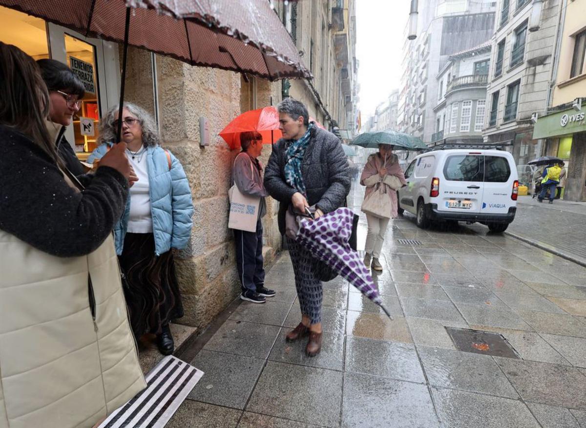 Pontevedreses se refugian de la lluvia. |  G. Santos