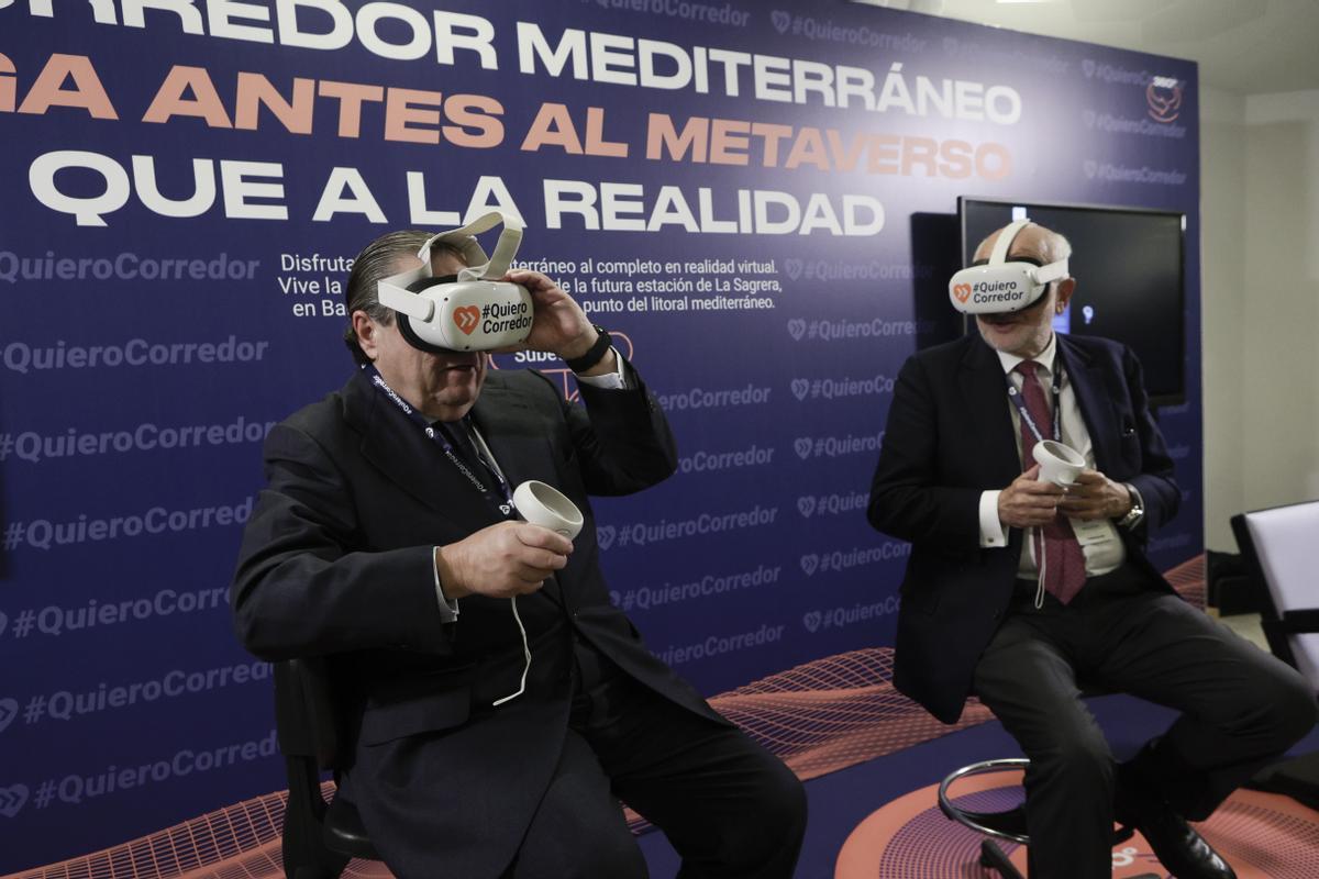 El presidente de la Asociación de Empresarios Valencianos, Vicente Boluda (izquierda) y el de Mercadona, Juan Roig (derecha), con gafas de realidad virtual, durante el acto empresarial celebrado en Barcelona para reclamar la finalización de las obras del corredor mediterráneo.