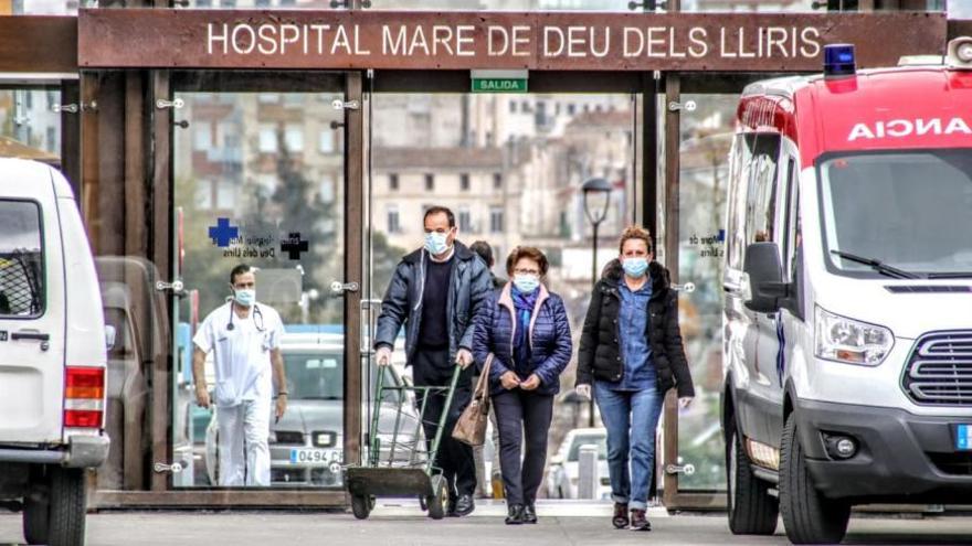 Personal sanitario y pacientes con mascarilla a la entrada del Hospital Virgen de los Lirios.