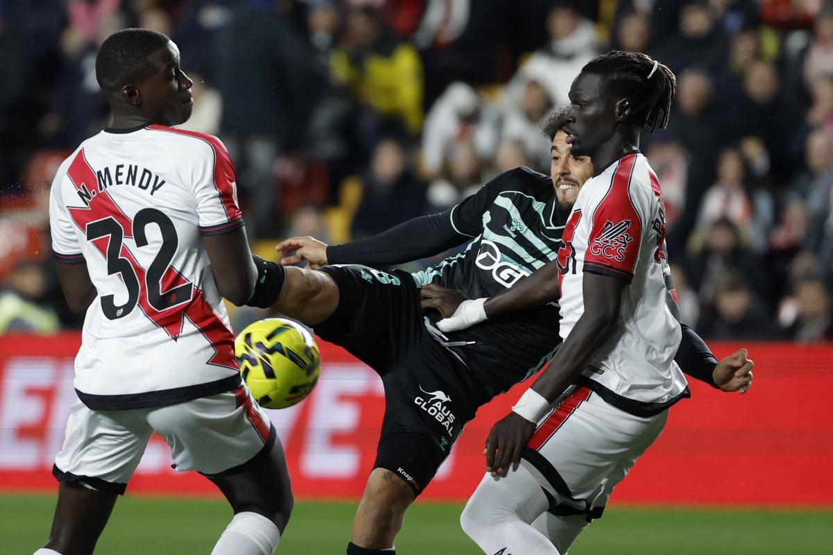 El centrocampista del Betis Pablo Fornals (c) intenta un remate ante Nobel Mendy (i) y Pathé Ciss, ambos del Rayo Vallecano.