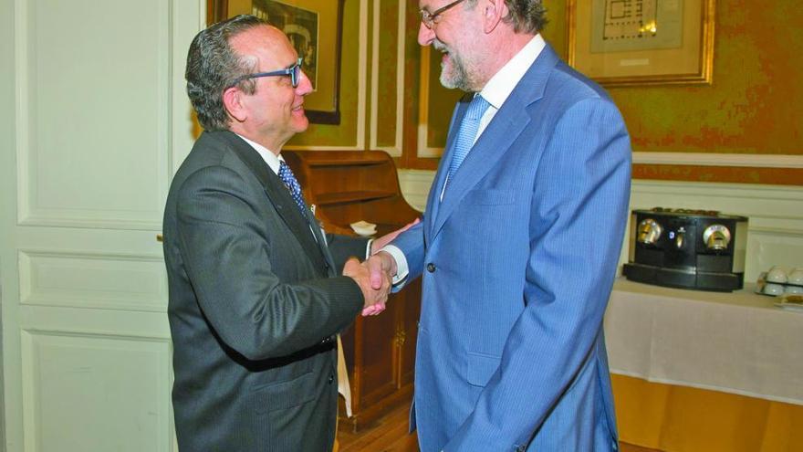 Javier Moll y Mariano Rajoy se saludan ayer en Madrid.