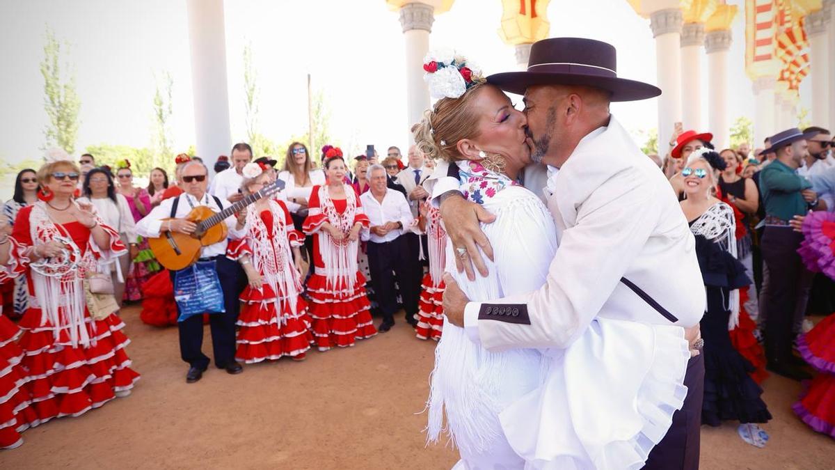 Beso espontáneo en la portada de la Feria, durante la actuación de un coro.